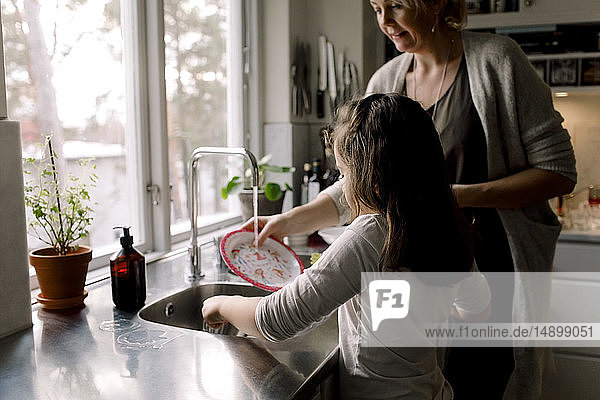 Tochter hilft der Mutter zu Hause in der Küche