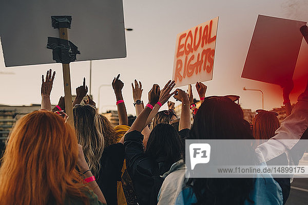 Rückansicht von jungen Frauen  die beim Marschieren in der Stadt für gleiche Rechte protestieren