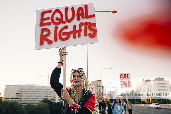 Frauen protestieren mit Freunden für Gleichberechtigung in Stadt gegen Himmel