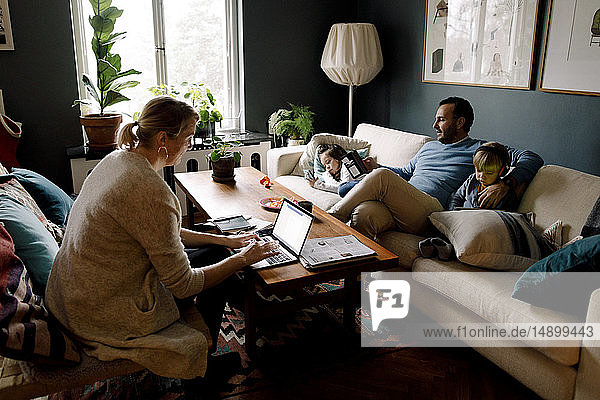 Family using various technologies in living room at home
