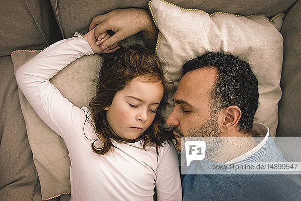 Direkt über der Aufnahme von Vater und Tochter  die zu Hause auf der Couch schlafen