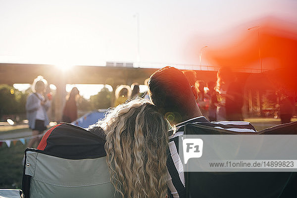 Rear view of loving couple enjoying in music festival against sky