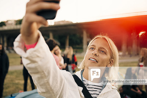 Close-up of man taking selfie on mobile phone during musical event