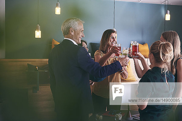 Glückliche Geschäftskollegen feiern Erfolg mit Getränken in der Büro-Cafeteria während der Party