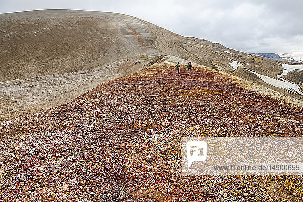 Two women backpacking on a ridge headed up Broken Mountain in the Valley of Ten Thousand Smokes  Katmai National Park and Preserve  Southwest Alaska; Alaska  United States of America