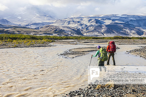 Two woman backpackers crossing the Katmai River  Katmai National Park and Preserve  Southwest Alaska; Alaska  United States of America