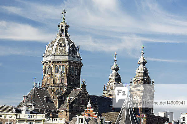 Großer Kuppelturm der Sankt-Nikolaus-Basilika mit zwei weiteren Türmen; blauer Himmel und Wolken; Amsterdam  Niederlande