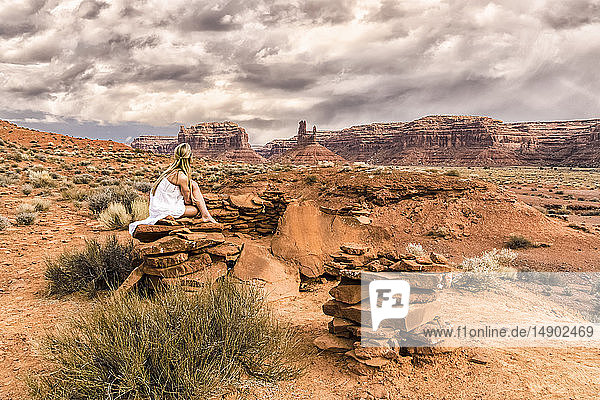 Eine Frau sitzt auf einem Felsen im Valley of the Gods; Utah  Vereinigte Staaten von Amerika