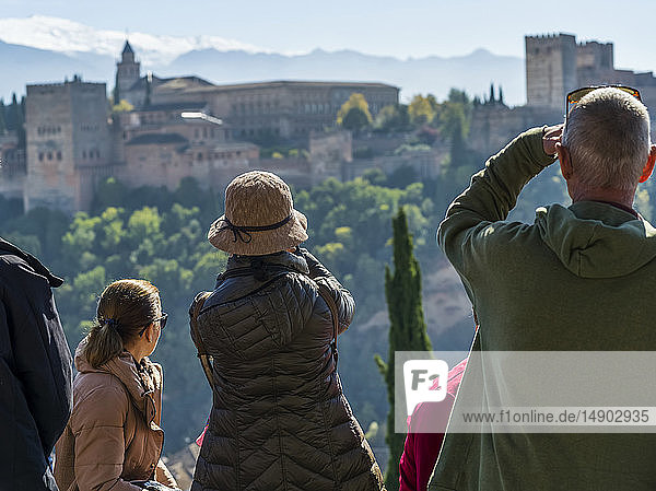 Tourists sitting with a view of the Alhambra; Granada  Andalusia  Spain
