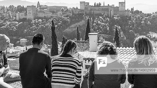 Touristen sitzen mit Blick auf die Alhambra; Granada  Andalusien  Spanien