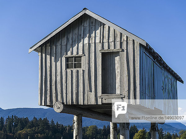 Wooden house on stilts with the Coast mountains in the background; Vancouver British Columbia Canada