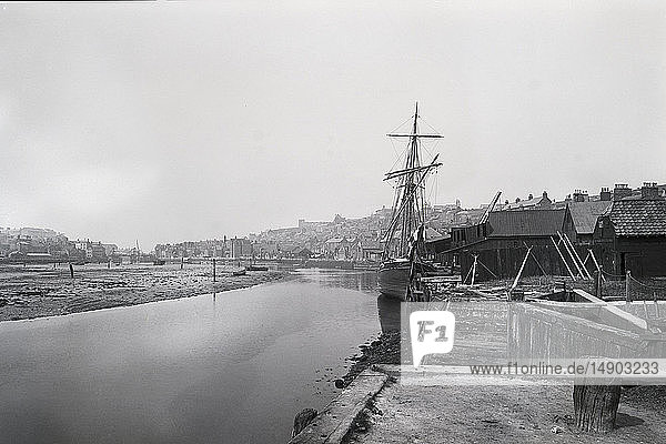 negativ 1900  viktorianische Ära. Der Fluss Esk bei Whitby mit einem Segelschiff  das im Hafen liegt und auf die Stadt blickt.