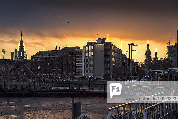Dramatischer goldener Himmel über einem städtischen Stadtbild bei Sonnenuntergang; Irland