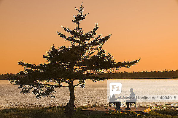 Ehepaar entspannt sich bei Sonnenuntergang an der Atlantikküste  Bay of Fundy; Blanche  Nova Scotia  Kanada