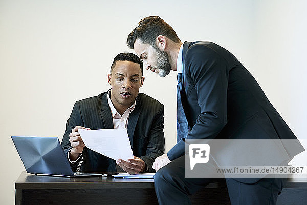 Geschäftsleute diskutieren über ein Dokument am Schreibtisch im Büro