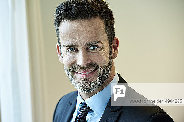 Close-up of smiling businessman standing in hotel