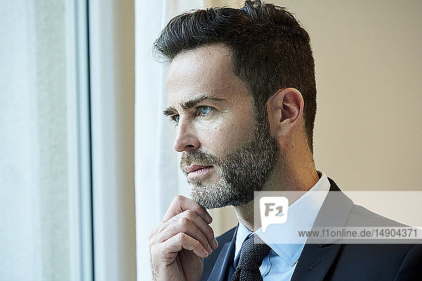 Businessman looking through office window
