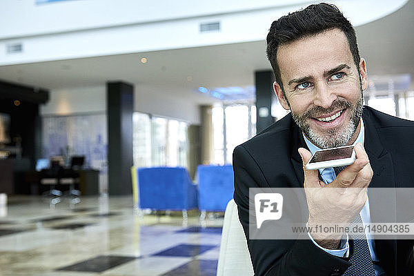 Businessman using smart phone while sitting on sofa