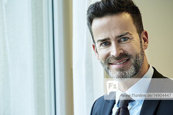 Smiling businessman standing in hotel