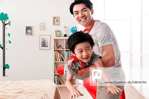 Happy father and son playing a superman