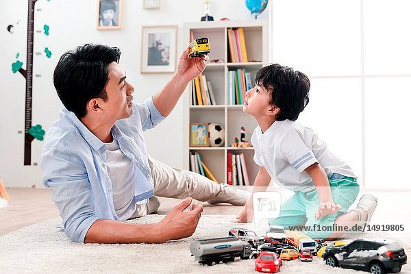 Happy father and son play in the living room