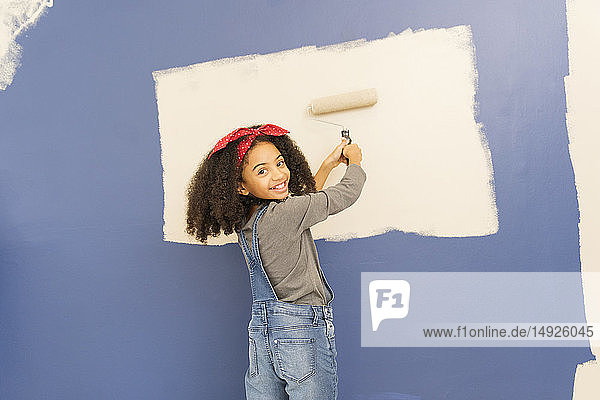 Porträt glückliches  selbstbewusstes Mädchen malt Wand