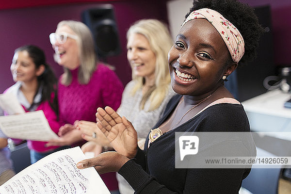 Happy woman singing in choir in music recording studio