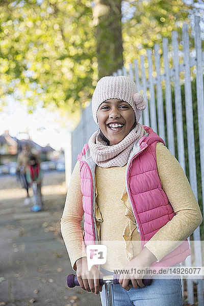Porträt lächelnd  glücklich Mädchen fahren Roller auf Herbst Bürgersteig