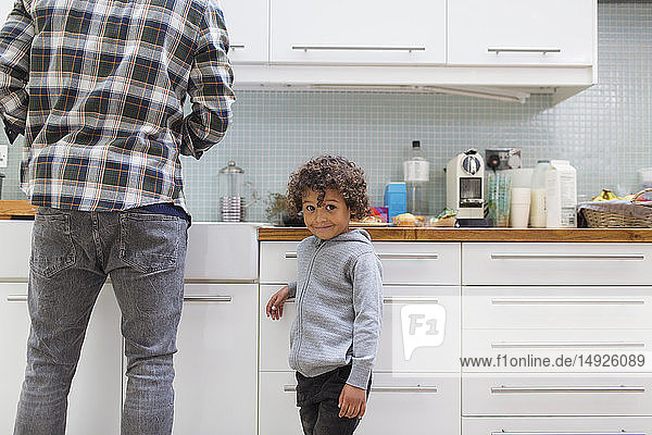 Portrait cute boy in kitchen with father