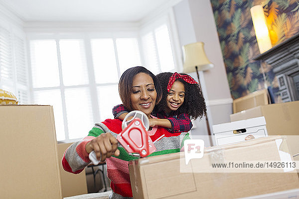 Affectionate mother and daughter packing  moving house