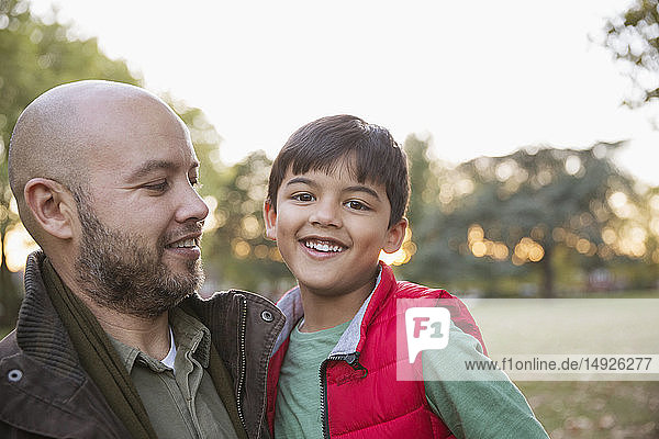 Portrait happy father and son in autumn park
