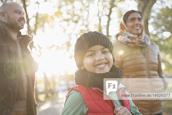 Portrait glücklicher Junge mit Eltern im sonnigen Herbstpark