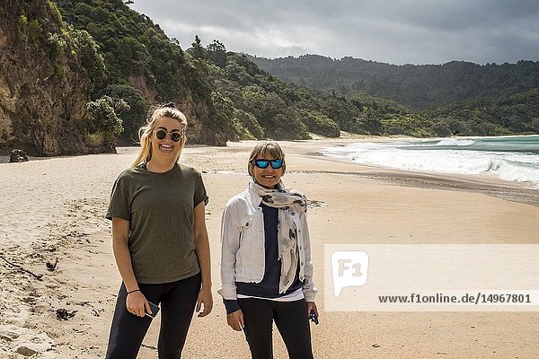 Two women on New China Beach on the Coromandel Peninsula  North Island  New Zealand.