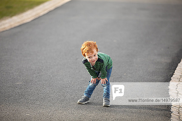 Boy stopping to rest on road