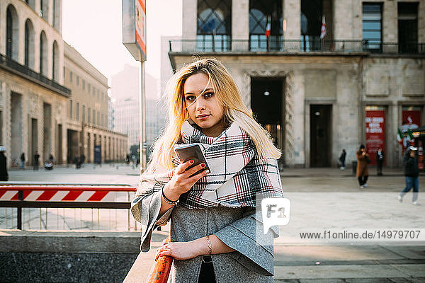 Junge Frau mit Smartphone bei der U-Bahn-Station  Portrait  Mailand  Italien