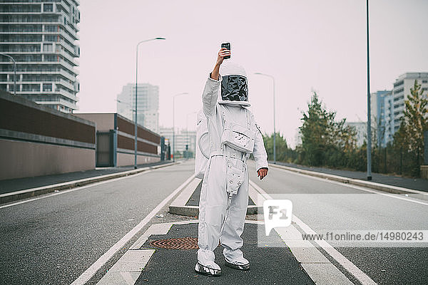 Astronaut beim Selbstfahren mitten auf der Straße