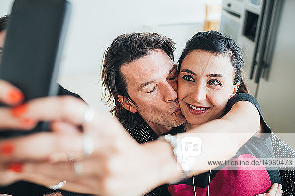 Couple taking selfie in loft office
