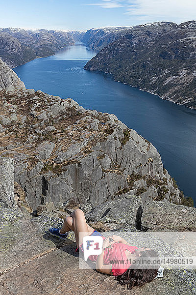 Wanderer der sich auf dem Gipfel einer Klippe ausruht Preikestolen (Kanzelfelsen) Lysefjord Norwegen Stavanger
