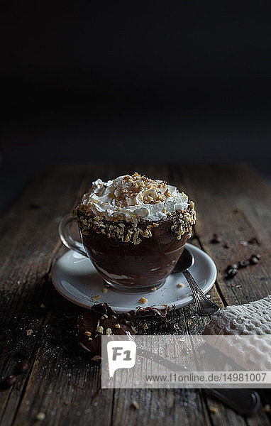 Tasse Schokoladenpudding mit Sahne und Nüssen