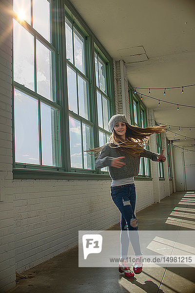 Teenage girl with long brown hair spinning in dance studio  portrait