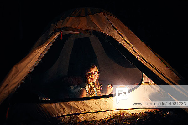 Mädchen nachts im Zelt