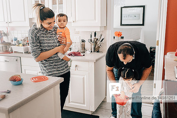 Paar mittlerer Erwachsener in der Küche mit Tochter und Baby-Sohn