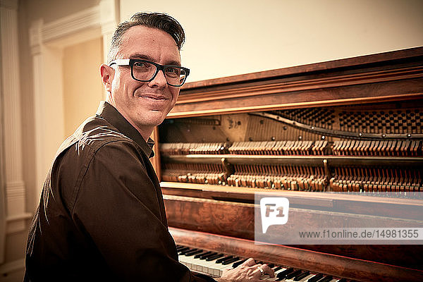 Mann lächelt und spielt Klavier