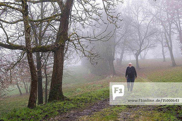 Man walking in the fog. Winter morning at rural house. Gers  Midi-Pyrenees  France. Europe.