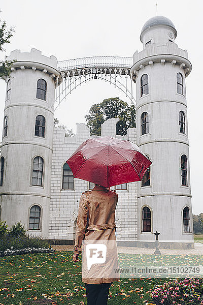 Frau mit rotem Regenschirm bei Schloss Pfaueninsel in Potsdam  Deutschland