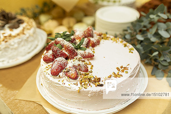 Cake topped with strawberries and pistachios