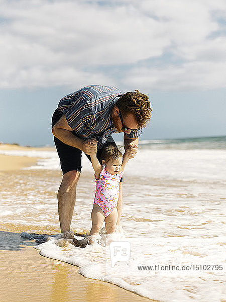Vater mit seinem kleinen Mädchen am Strand