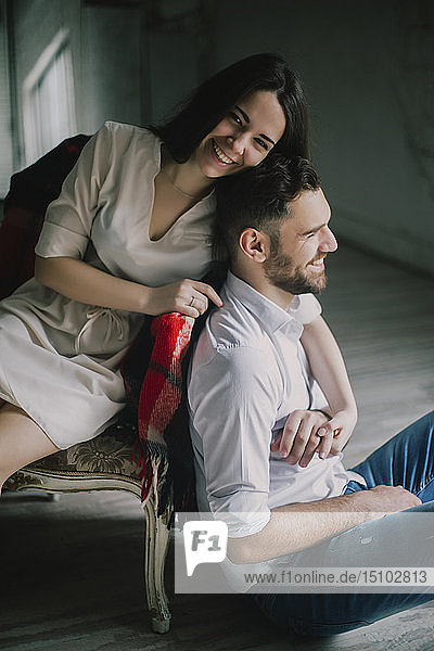 Lächelndes junges Paar mit Sofa