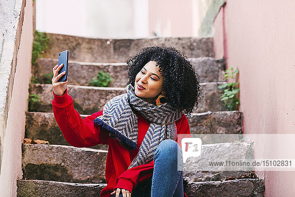 Junge Frau nimmt Selfie auf Stufen