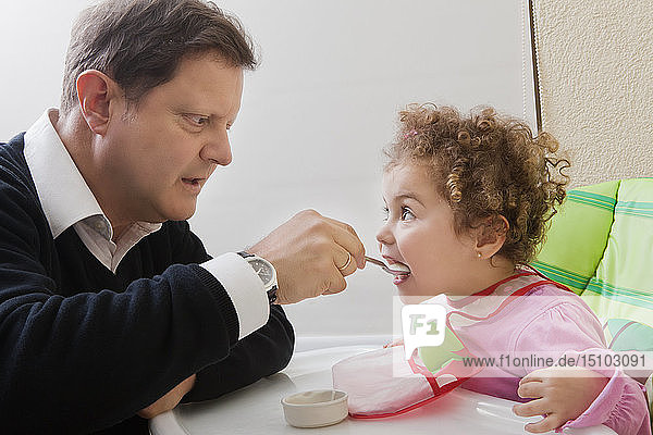 Vater füttert seine Tochter